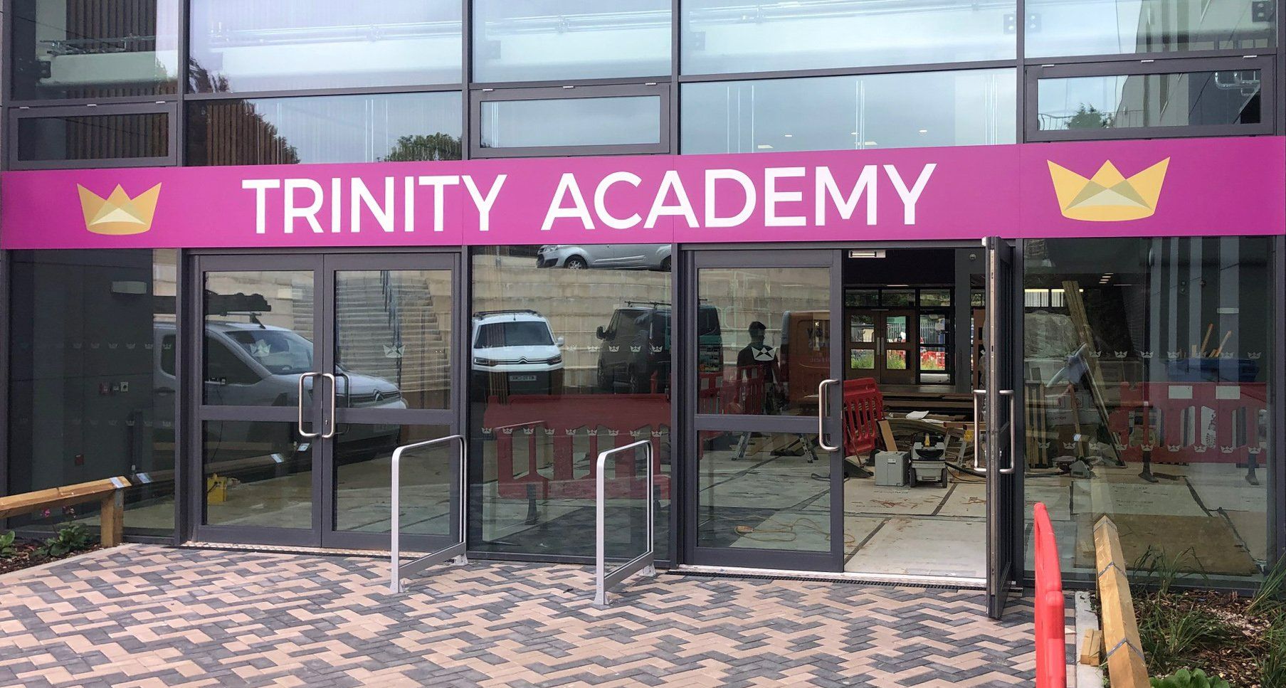 A large building with a sign that says trinity academy on it.
