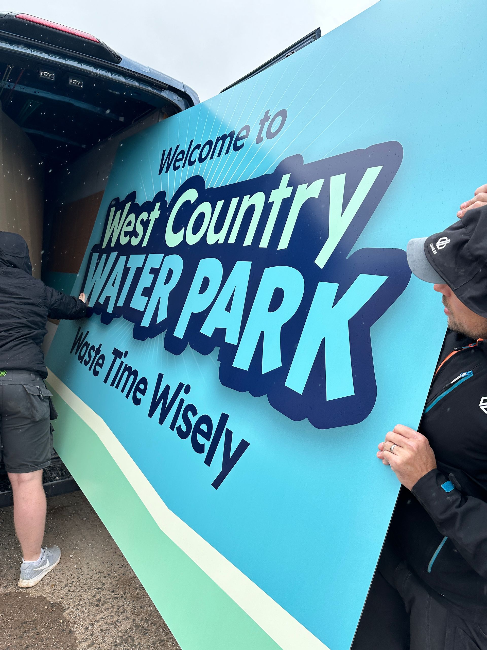 N3 Display Graphics | Two people are holding a large sign that says west country water park