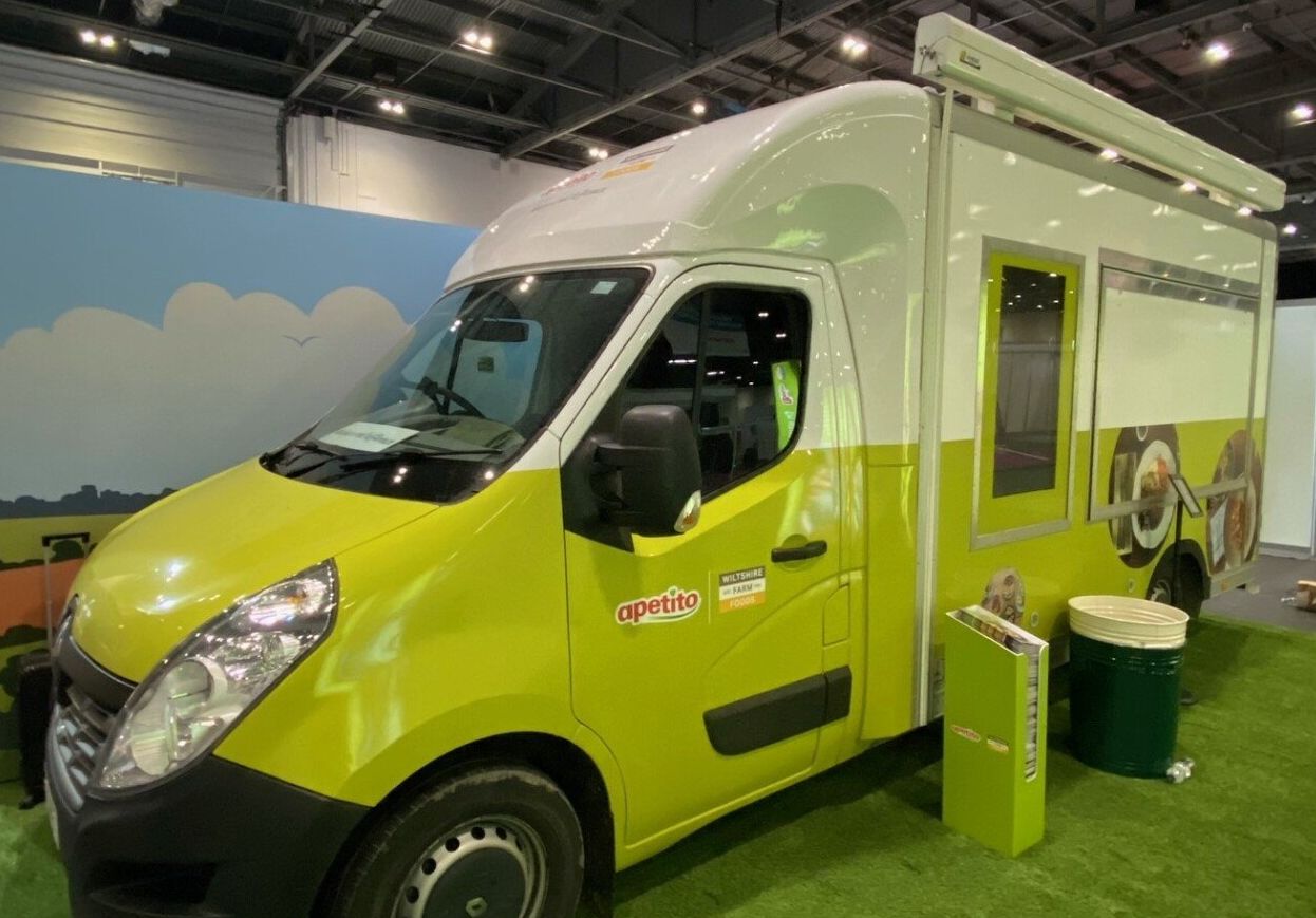 A yellow and white van is parked in a building.