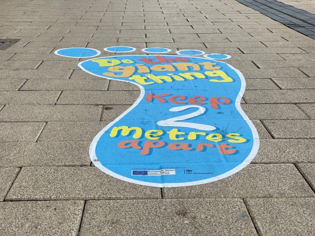 A footprint on the sidewalk that says `` keep 2 metres apart ''