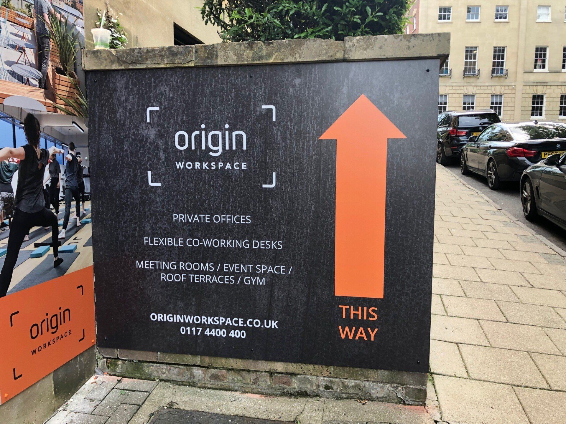 A black sign with an orange arrow pointing to origin
