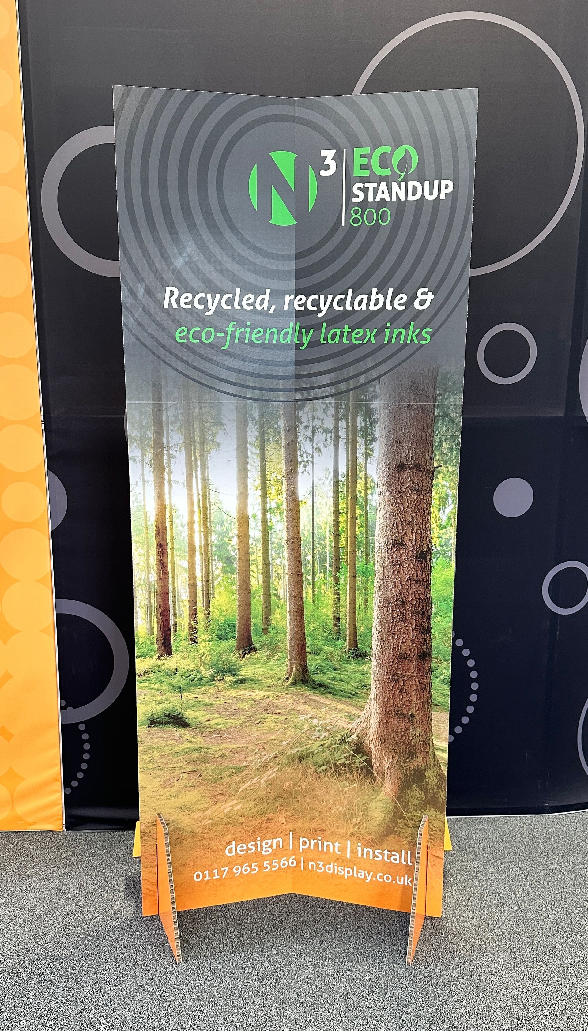 A sign with a picture of a forest on it is sitting on a table.