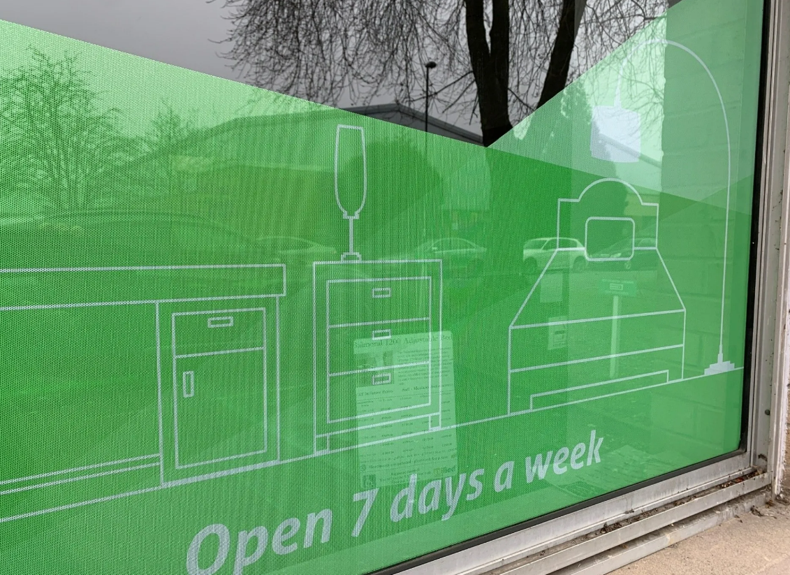 A green window with a blueprint of a house on it and the words `` open 7 days a week ''.