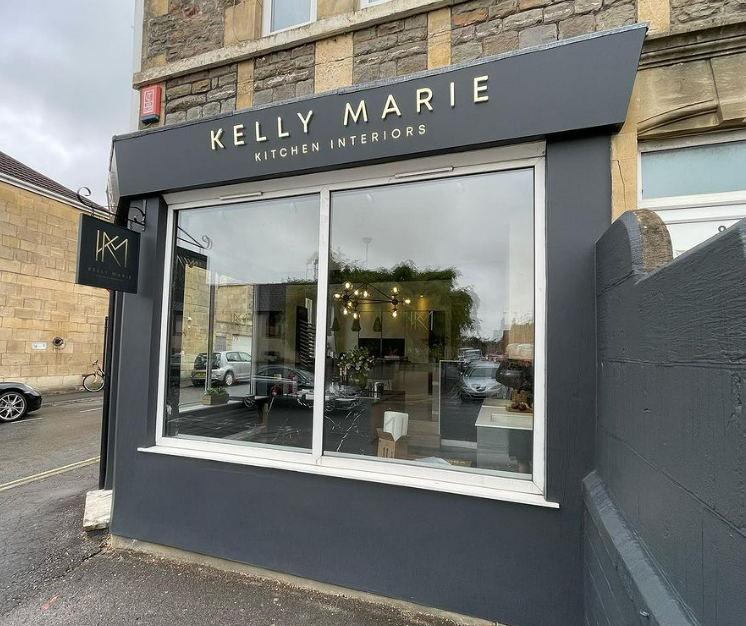 A kelly marie kitchen interiors store front with a large window.