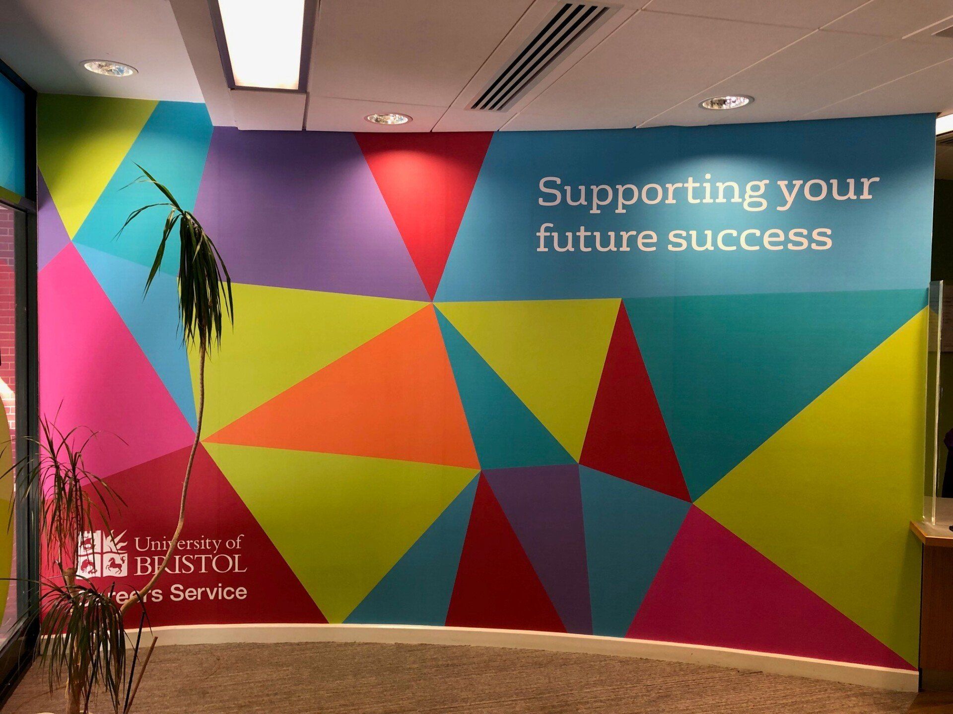A colorful wall with the words supporting your future success on it