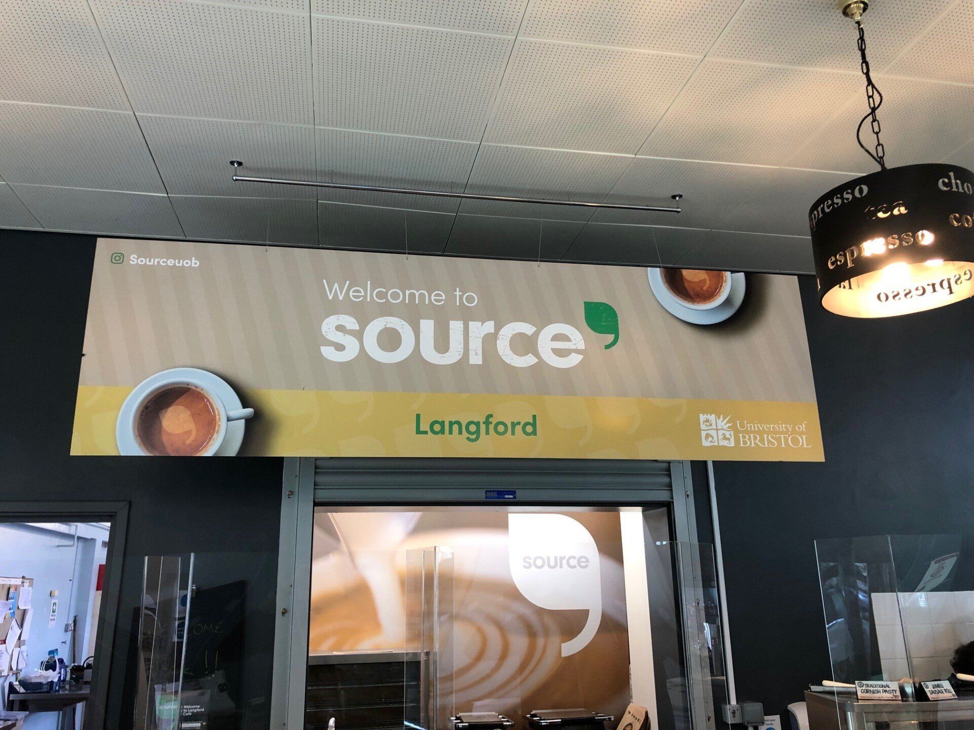 A sign hanging from the ceiling that says source langford