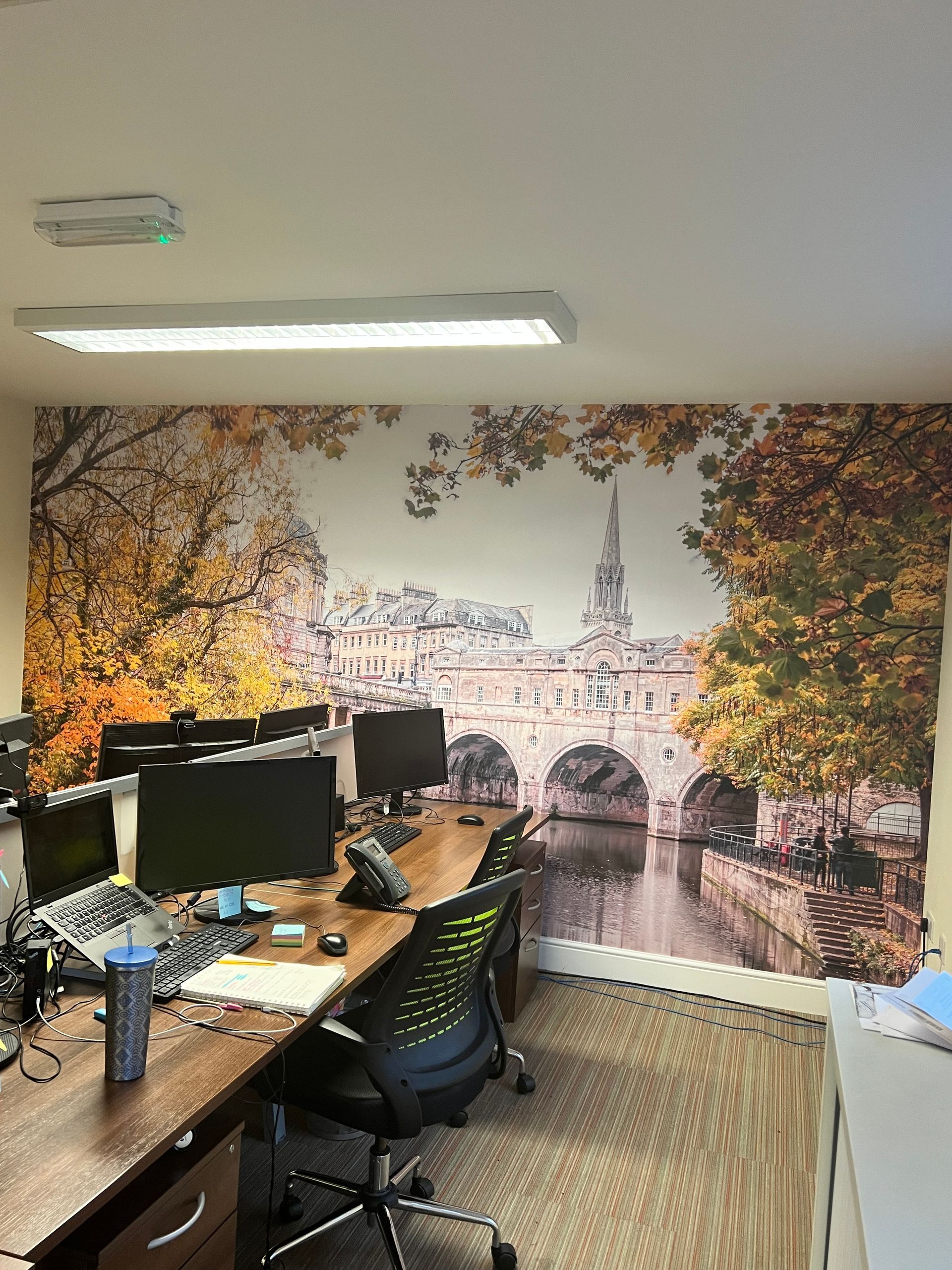 A room with a picture of a bridge on the wall.