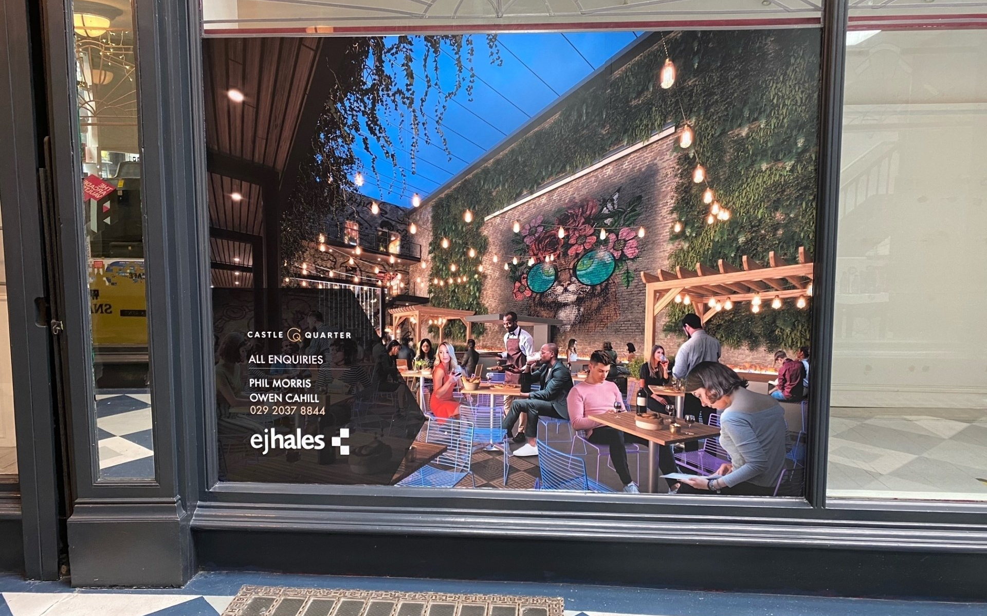 A window with a picture of people sitting at tables in a restaurant.