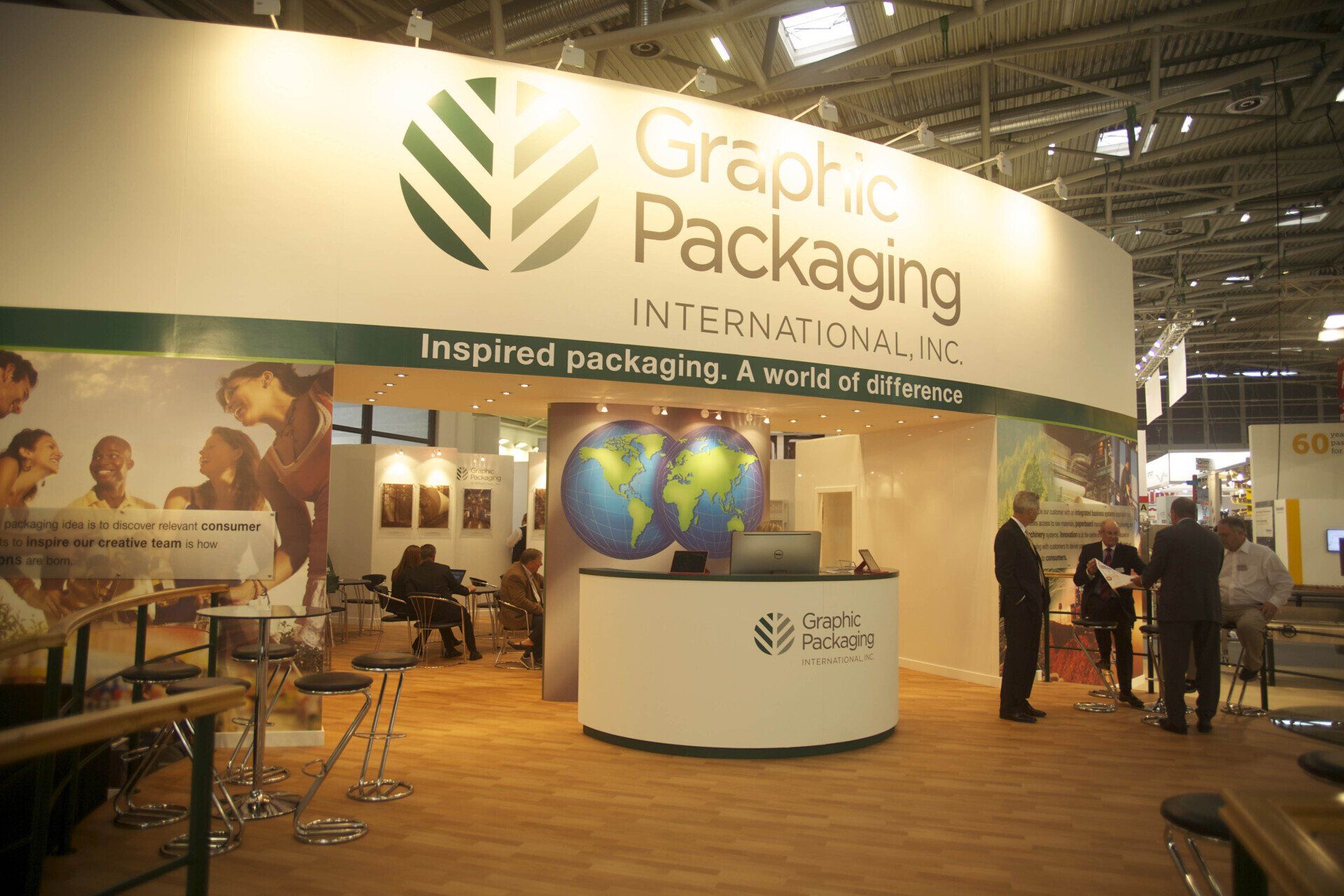 A group of people standing around a graphic packaging booth