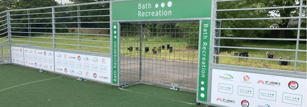 A soccer field with a goal and a fence around it.