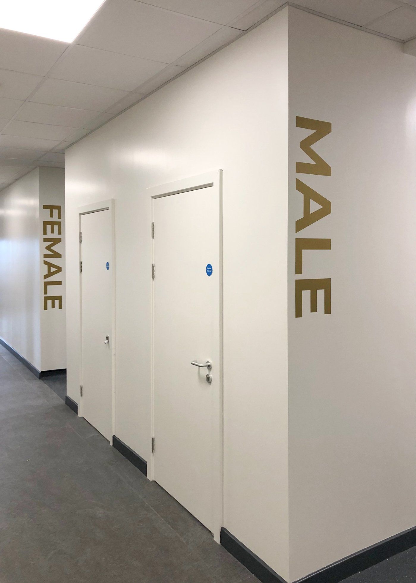 A hallway with a sign on the wall that says male and female