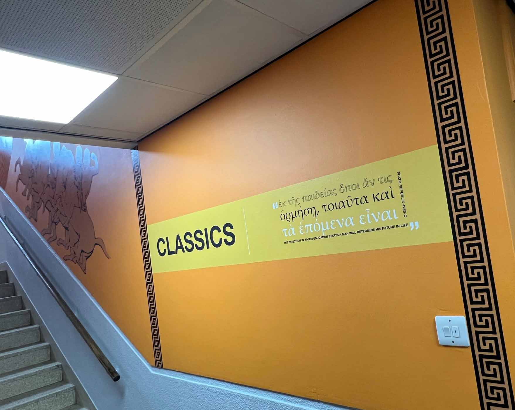 A staircase with a sign on the wall that says classics