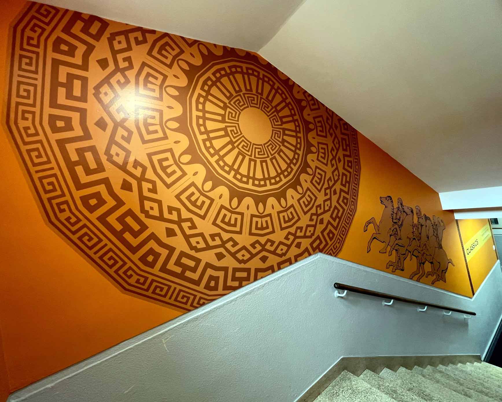 A staircase with a greek key design on the wall