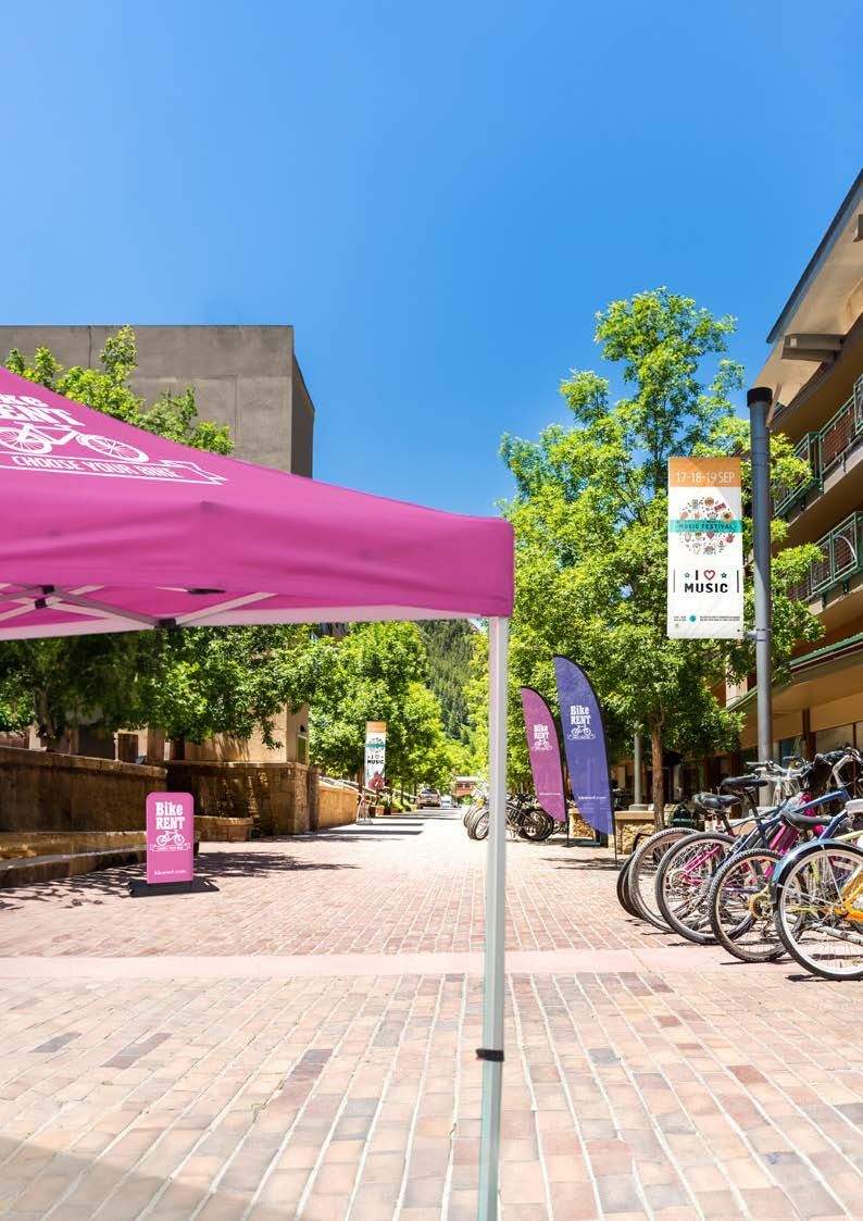 N3 Display Graphics | A pink tent is sitting on a brick sidewalk next to a row of bicycles.