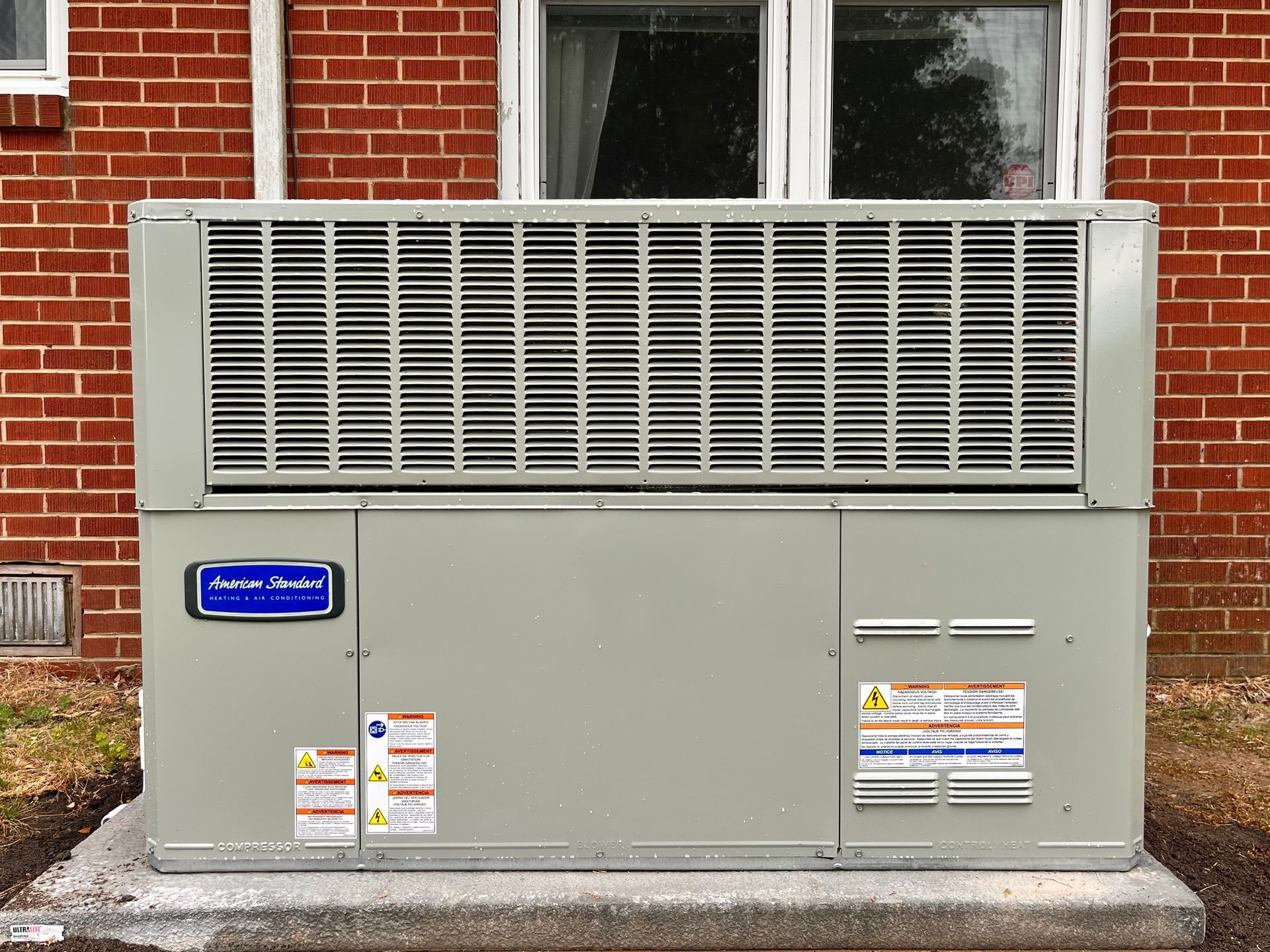 an air conditioner is sitting outside of a brick building