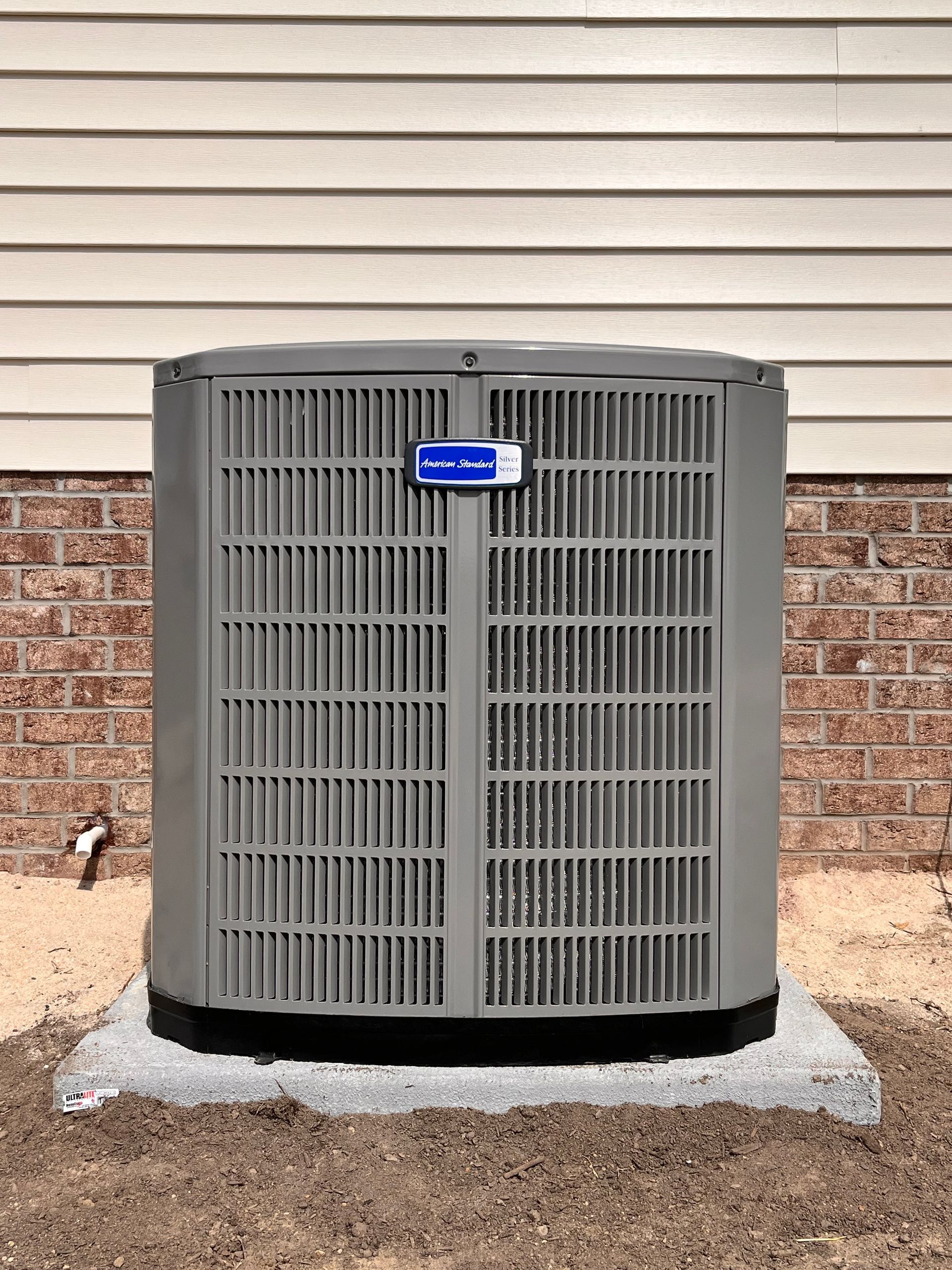 a large air conditioner is sitting outside of a brick building .