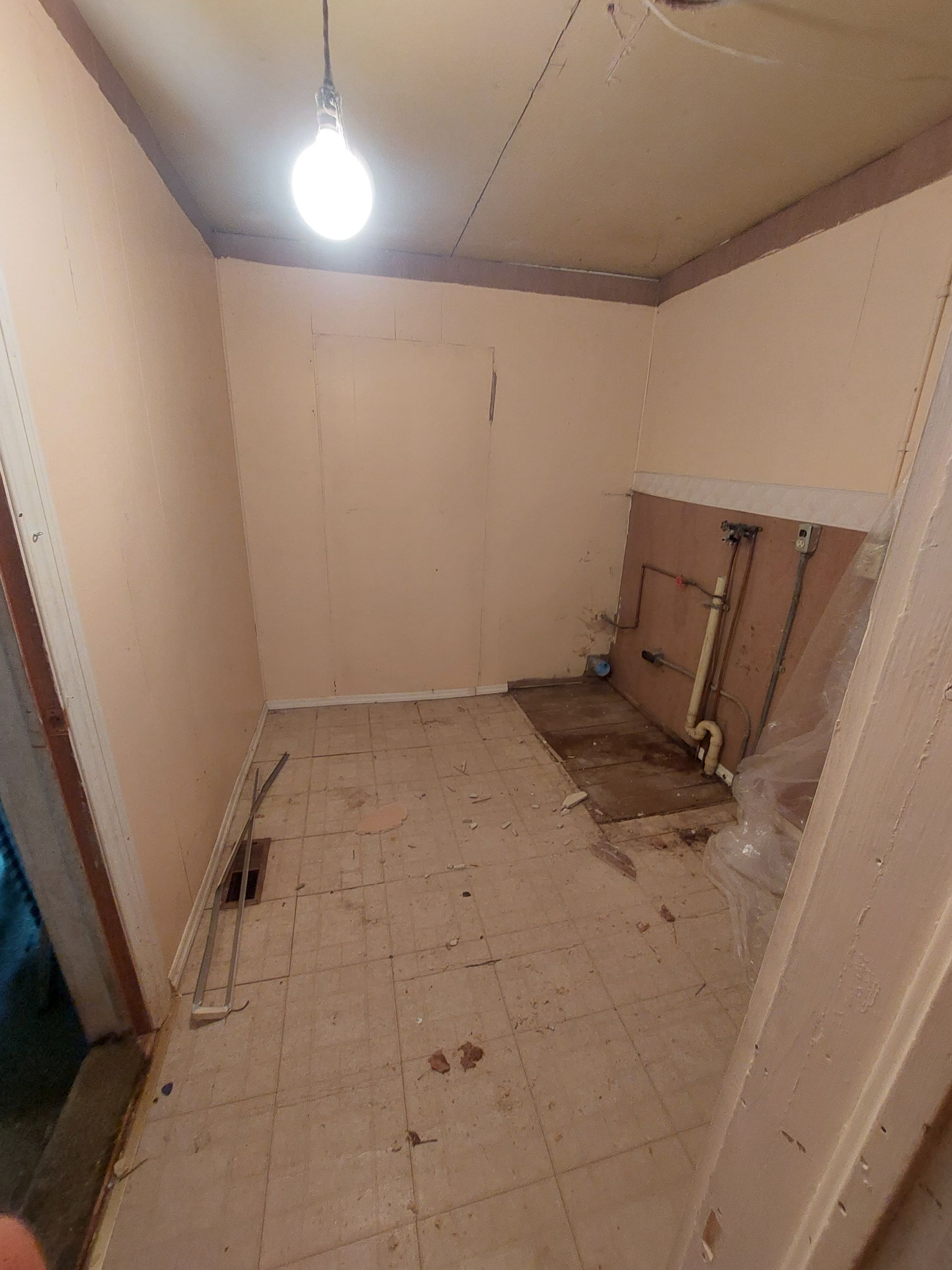 An empty room with a light hanging from the ceiling.