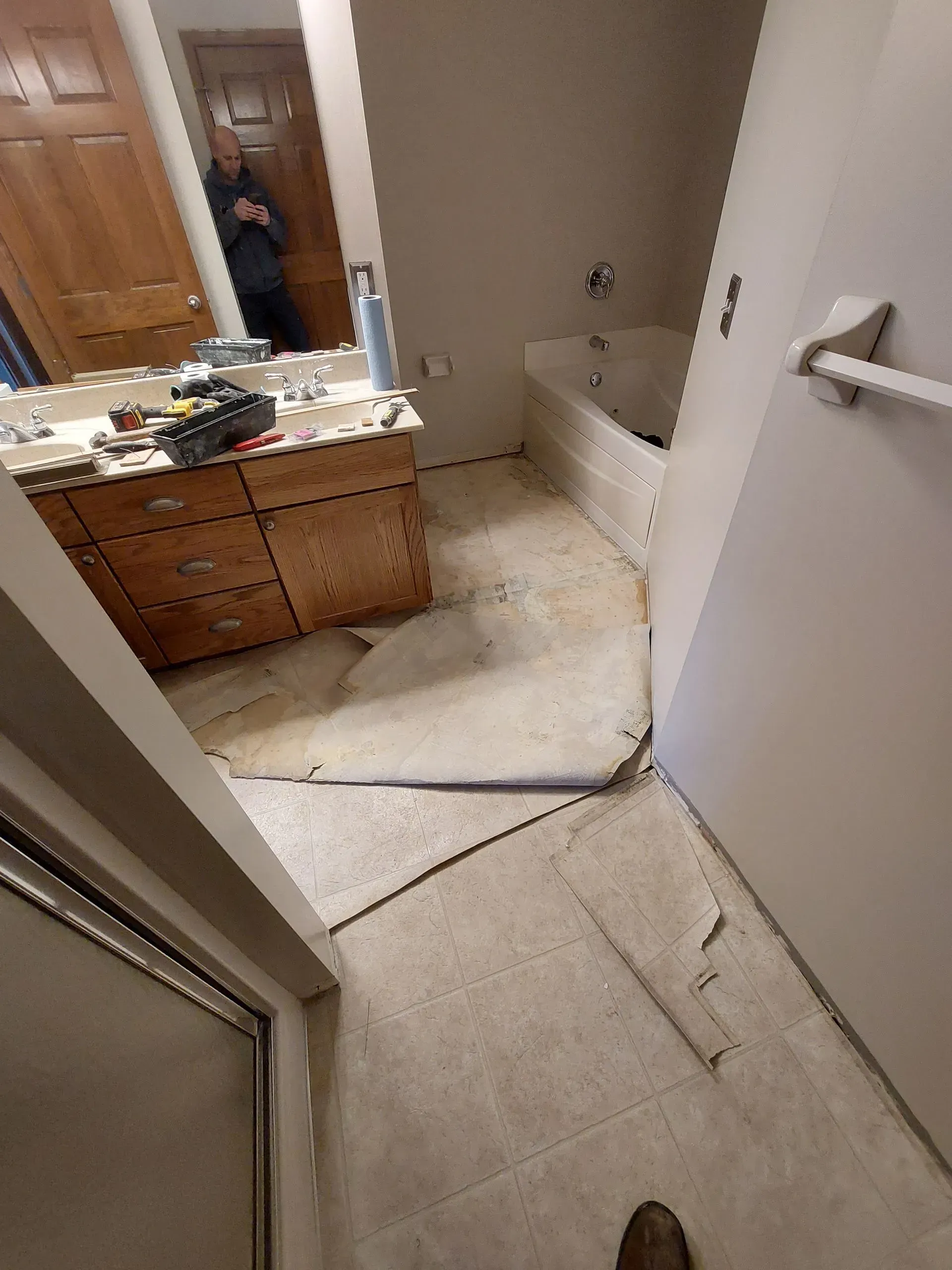 A bathroom with a bathtub , sink , and mirror.