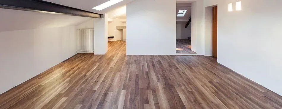 An empty room with a wooden floor and white walls.