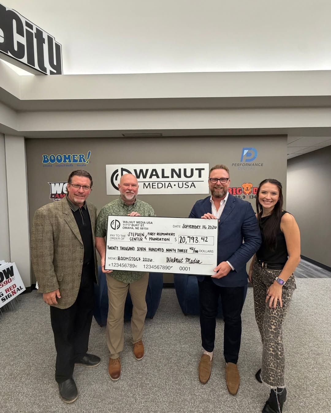 Four people holding a large ceremonial check.