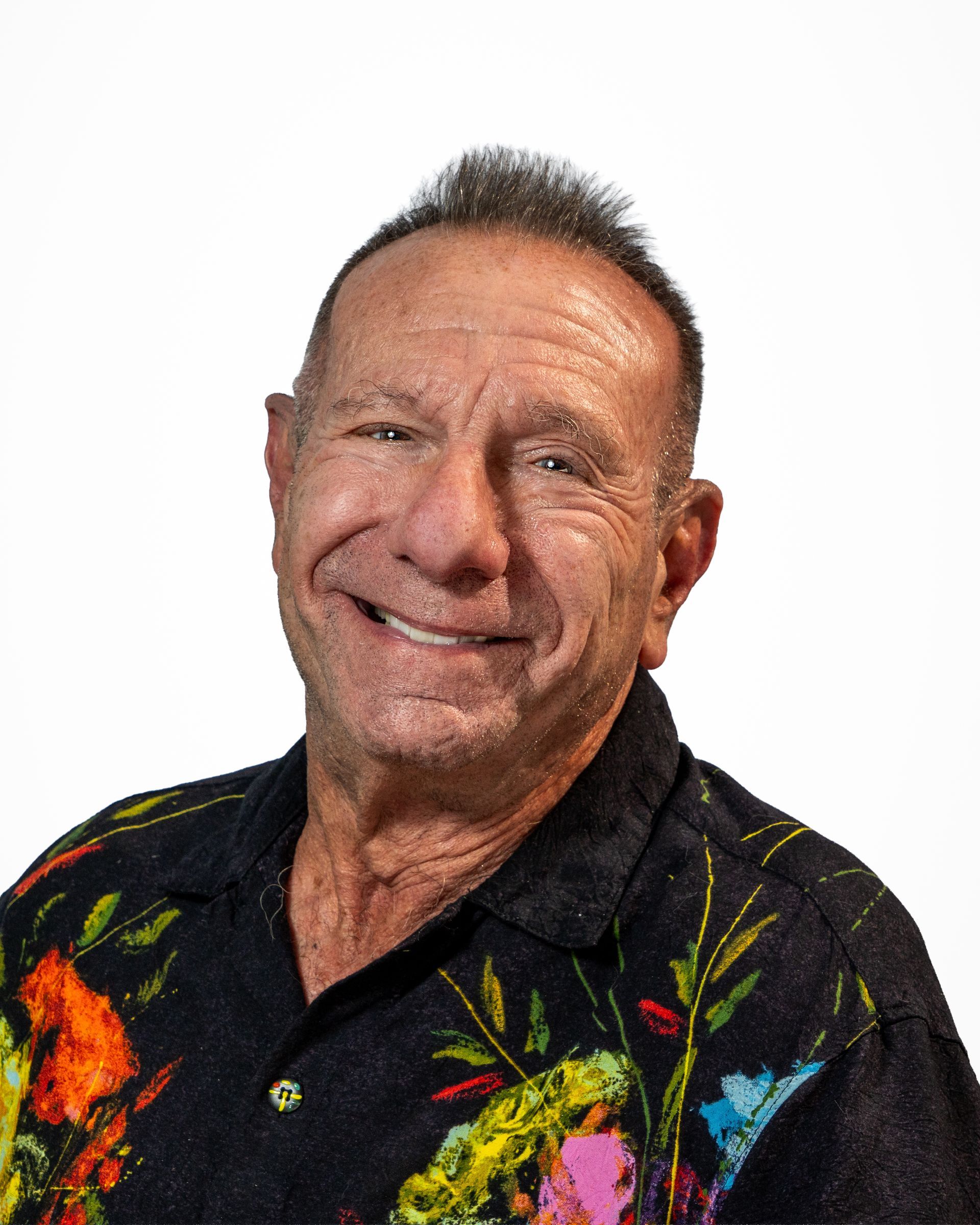 Smiling man in a black shirt against a gray studio backdrop