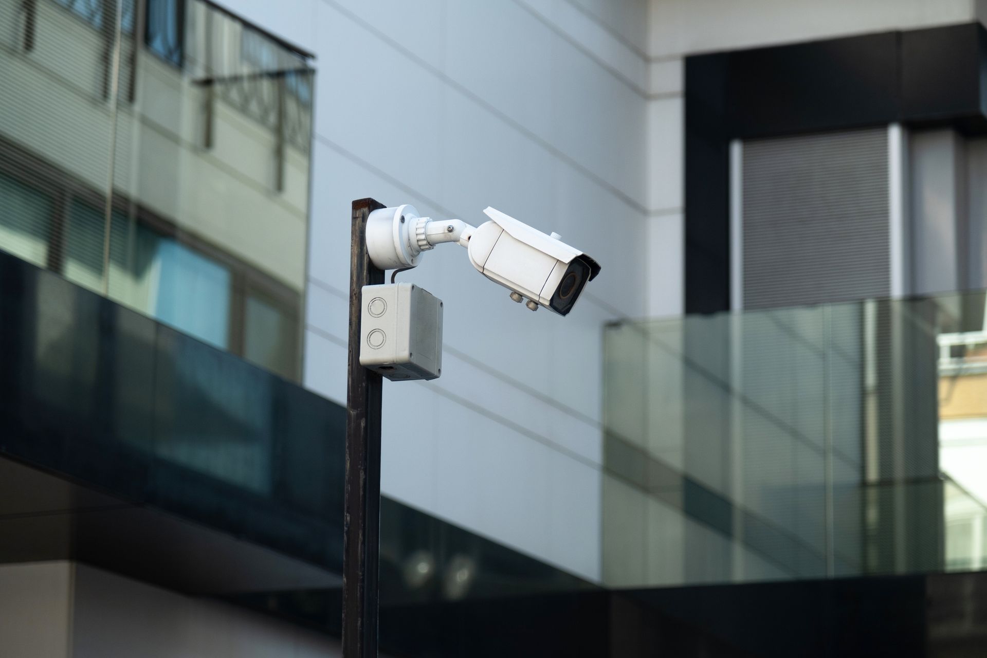 Telecamera di sicurezza montata su un palo, orientata verso la facciata di un edificio.