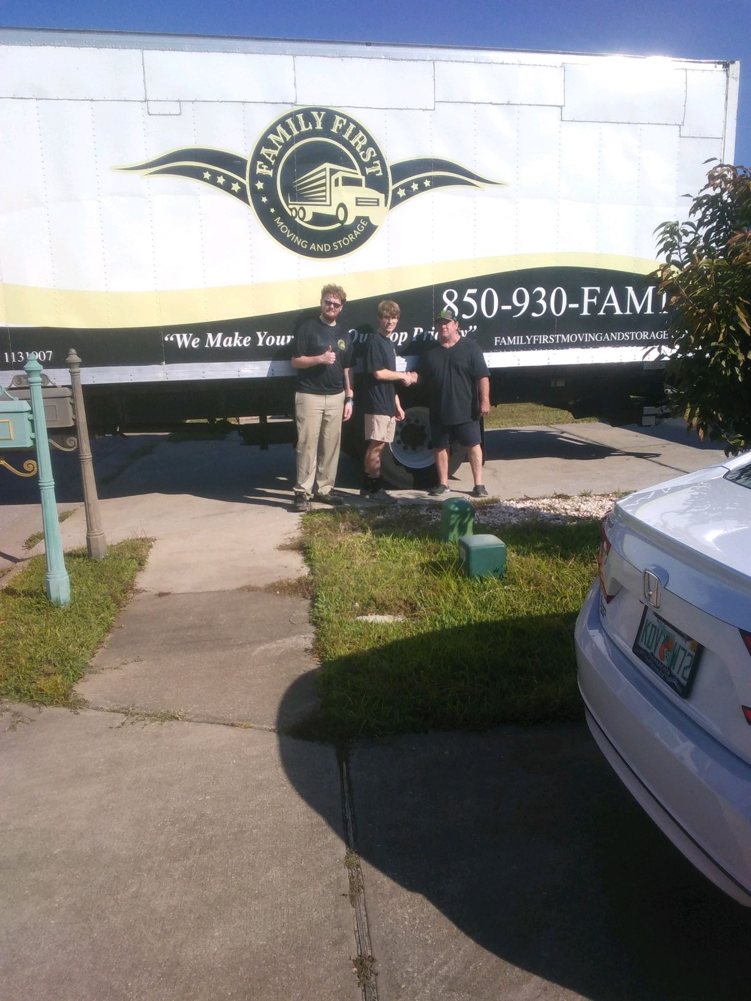 A group of people standing in front of a moving truck