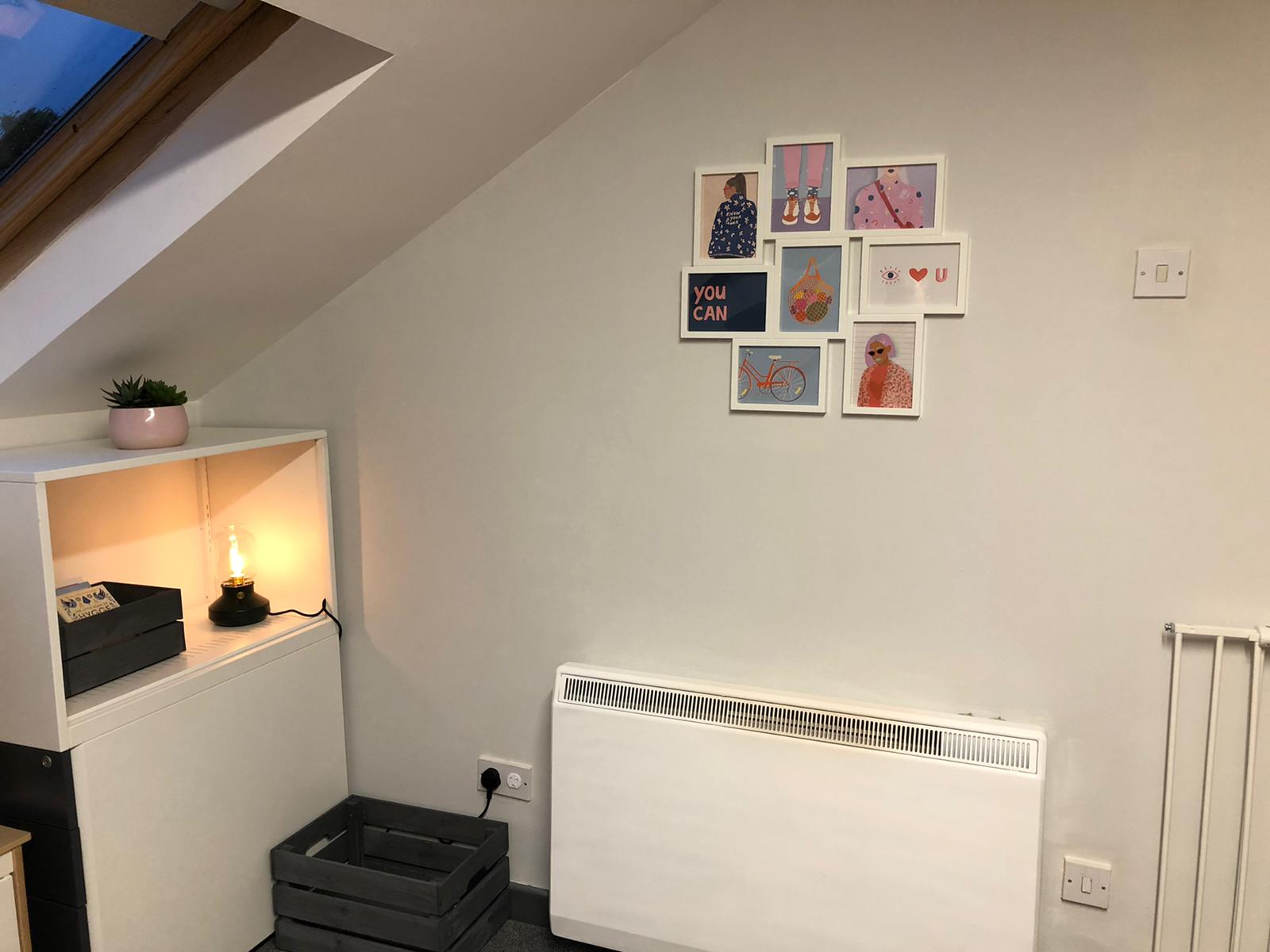 A room with a picture collage on the wall and a radiator. Dramatherapy Ireland