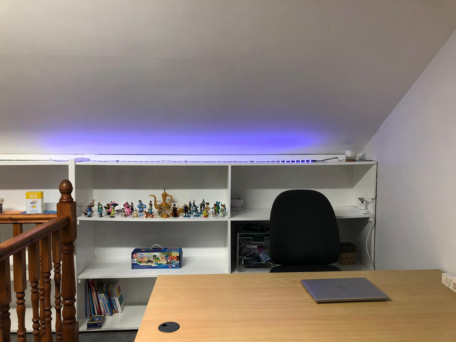 A desk with a laptop on it in a room with shelves. Dramatherapy Ireland