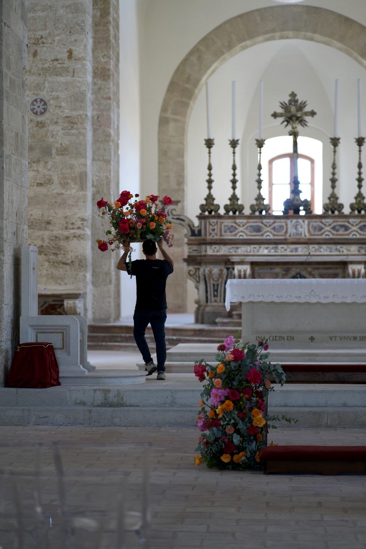 Un allestimento floreale viene portato verso l’altare nella navata di una cattedrale