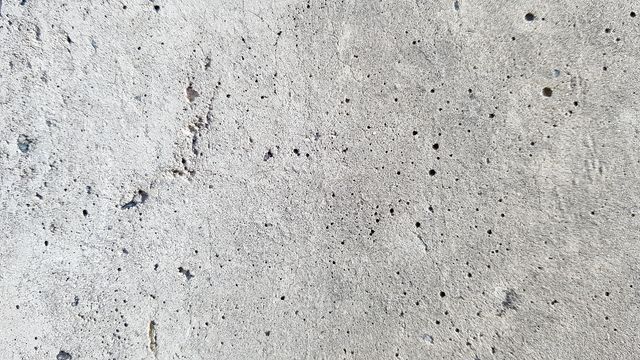 A close up of a concrete wall with holes in it.