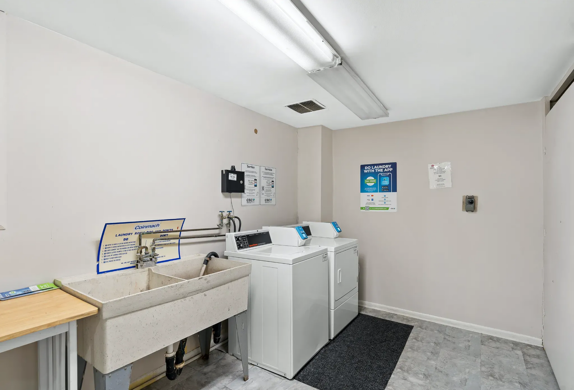 Laundry room with washers, dryer, and utility sink.