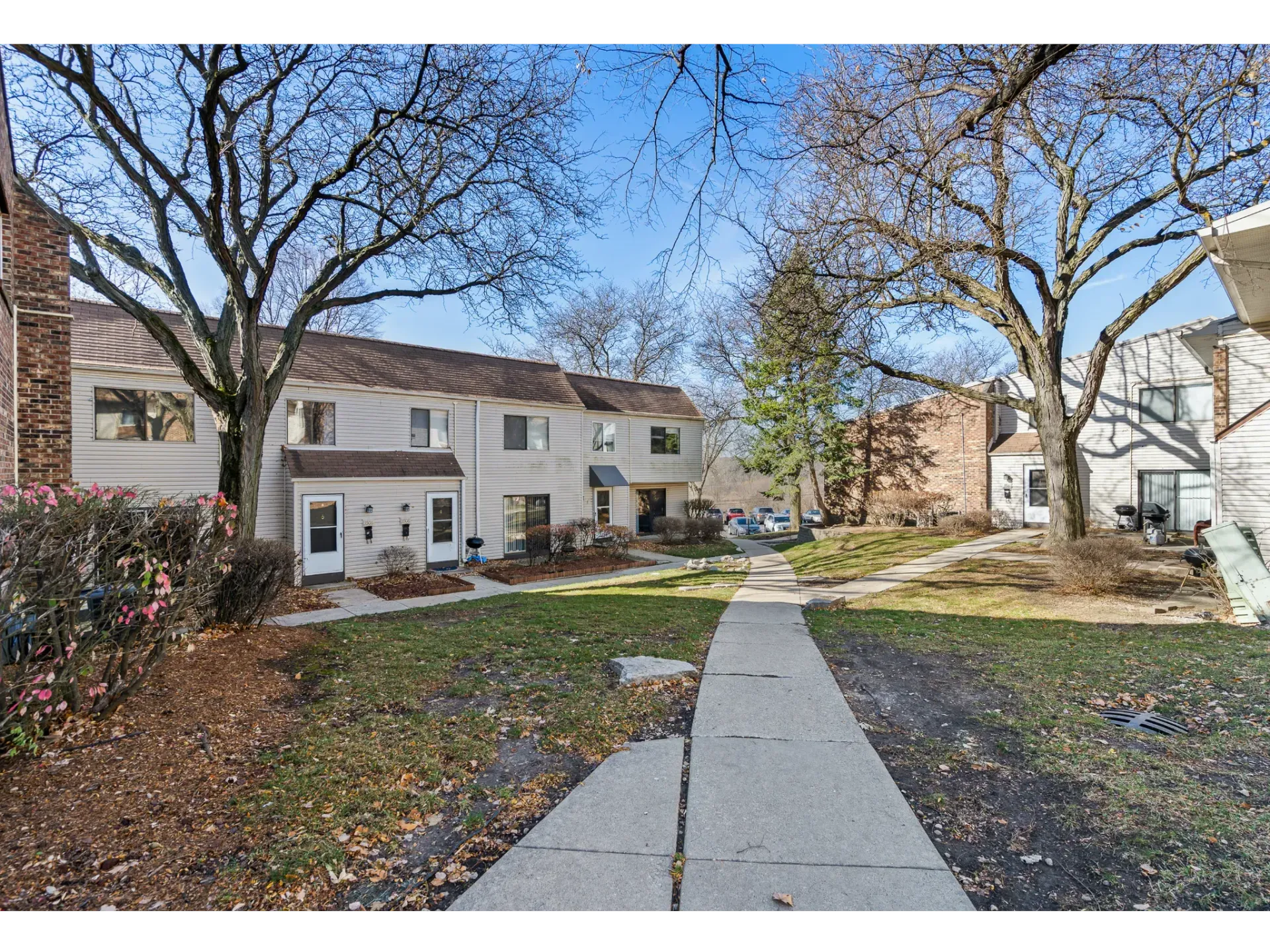 Exterior view of a residential complex with a pathway and trees