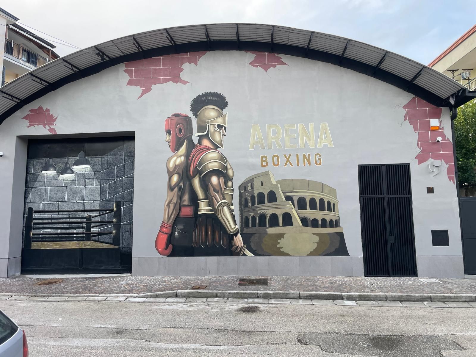 Murale raffigurante un pugile sulla facciata di un edificio con la scritta