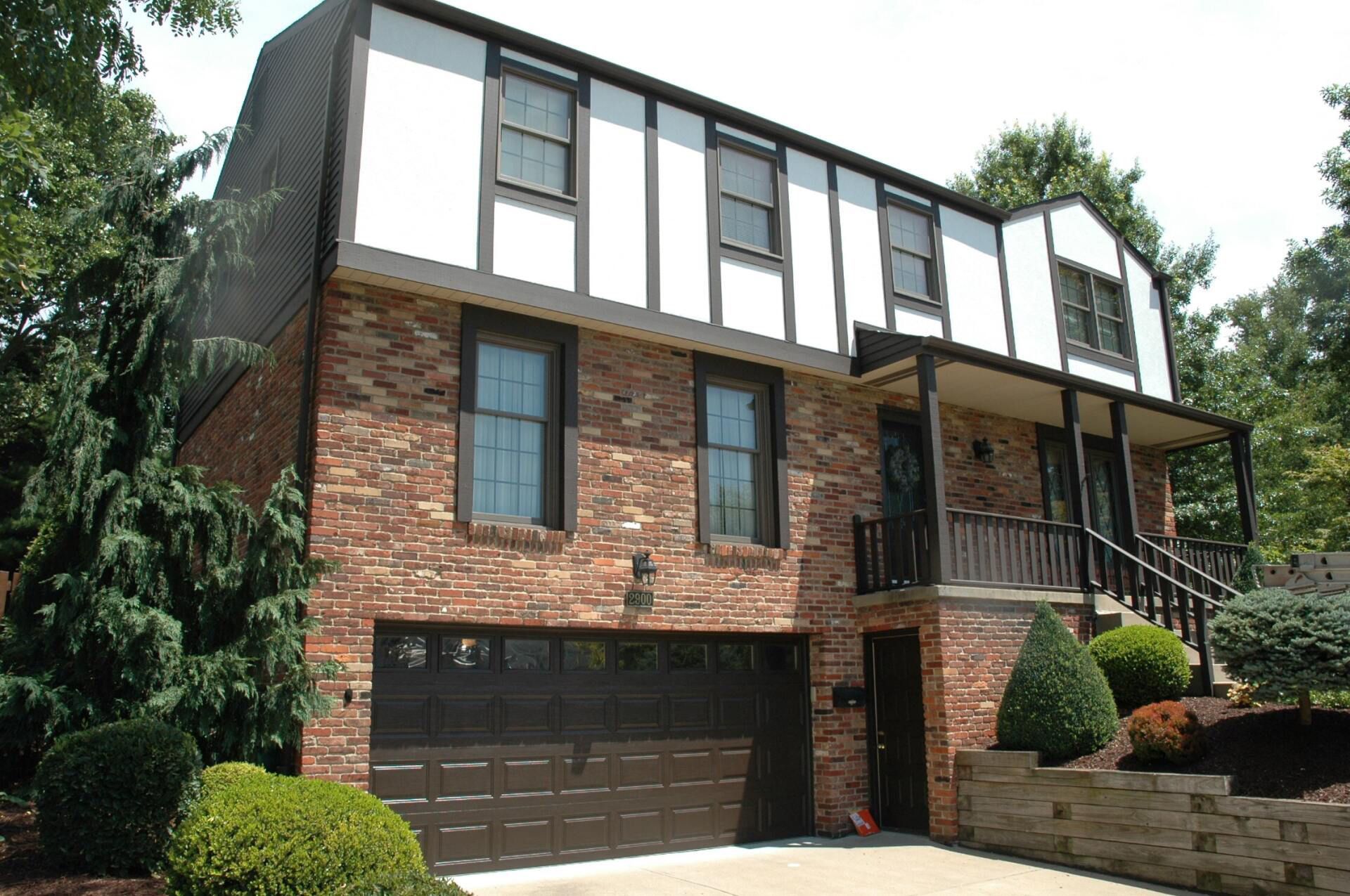 A large brick house with a black garage door