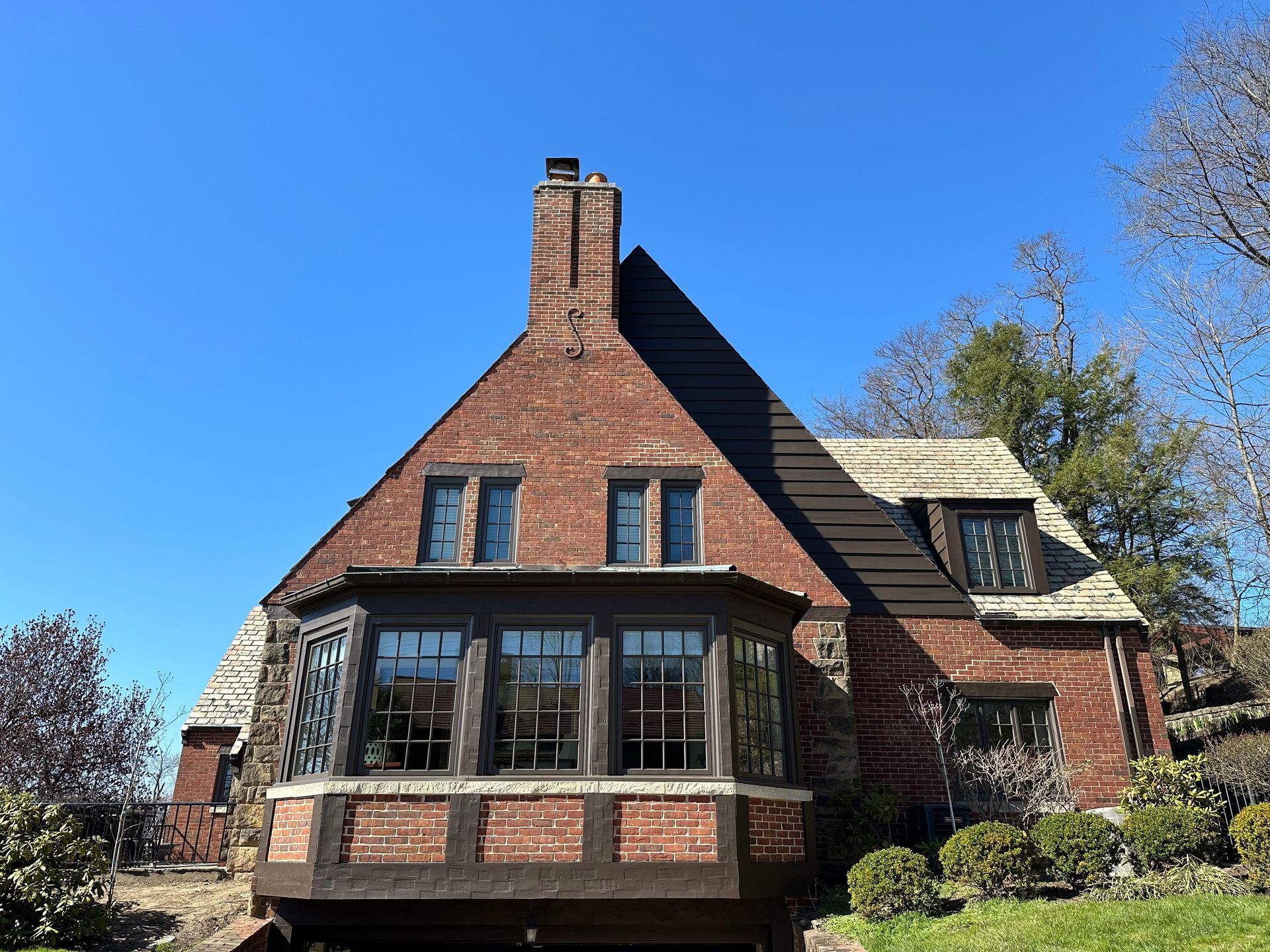 A large brick house with a lot of windows and a chimney