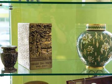 Présentation d'urnes funéraires : modèles dorés, verts et texturés.