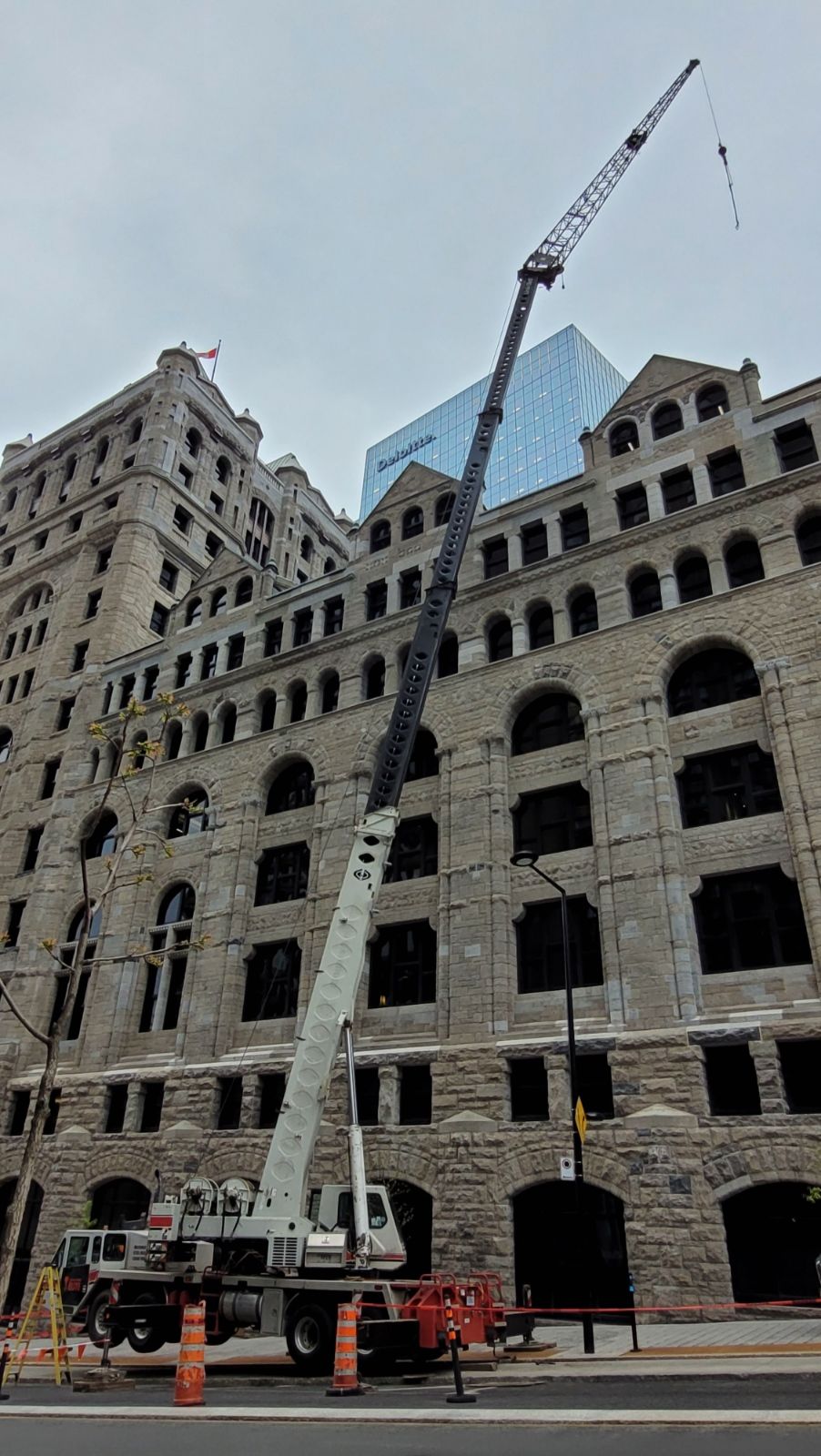 A large crane is sitting in front of a large building.