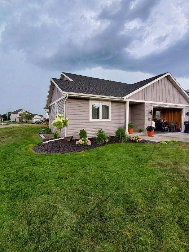 A small house with a large lawn in front of it.