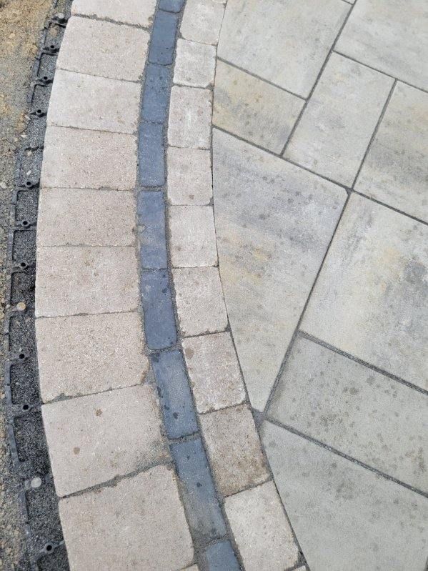 Close-up of custom paver walkway border and accent detail installed in Janesville, WI.
