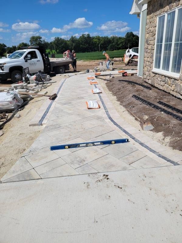 Custom paver walkway under construction beside a home in Janesville, Wisconsin.