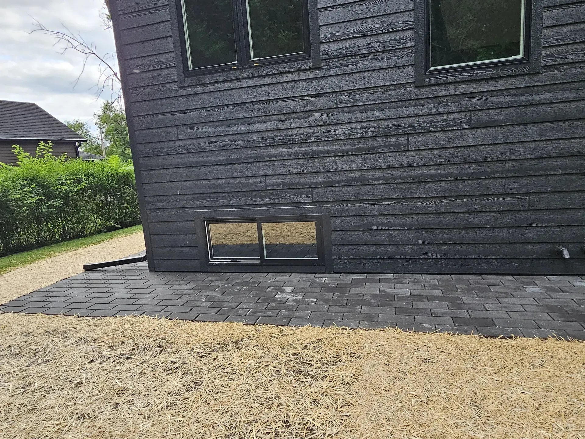 Charcoal paver patio and walkway wrapping the corner of a new construction home near Janesville, WI