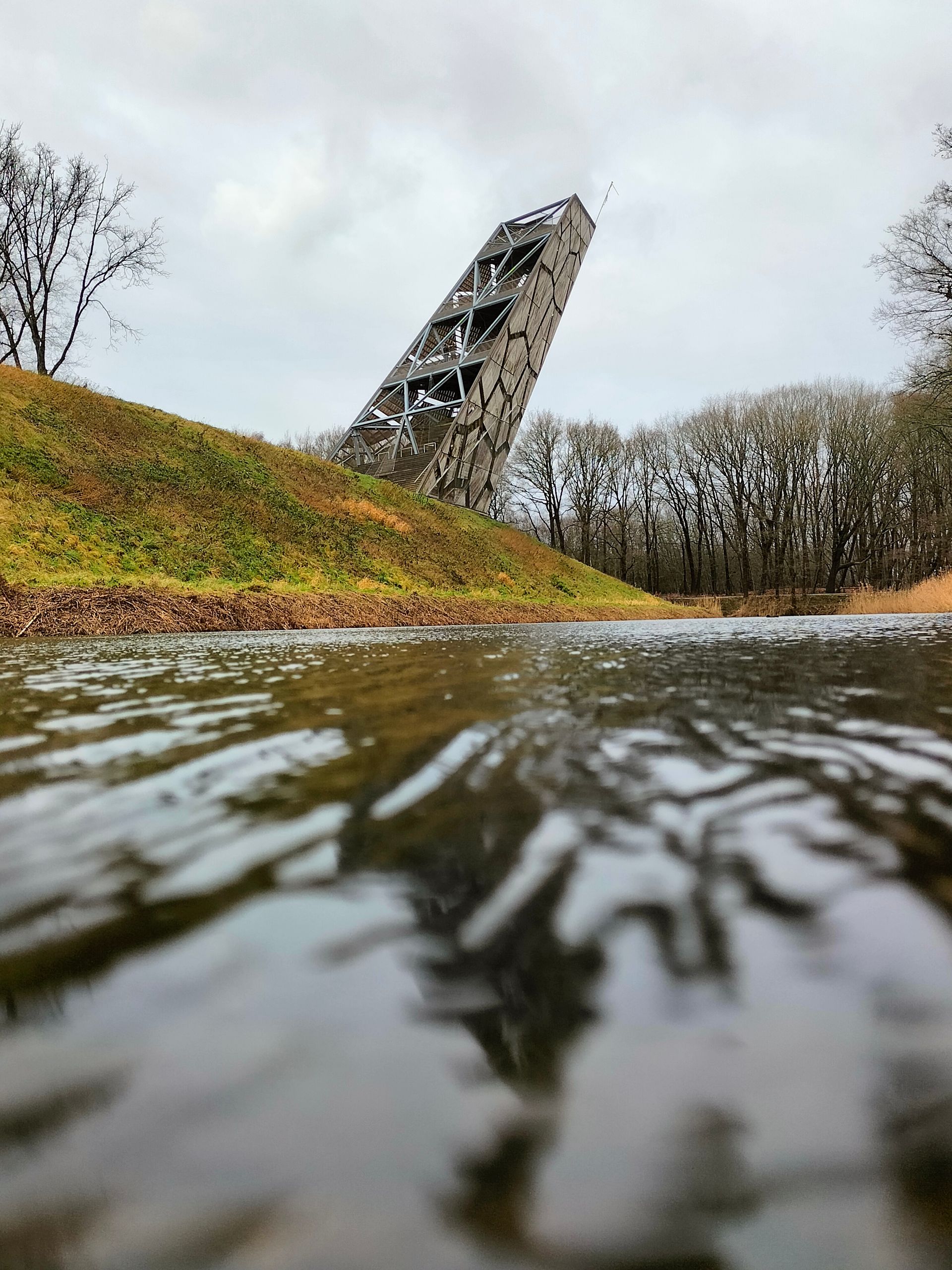 Een grote rots wordt weerspiegeld in een watermassa.