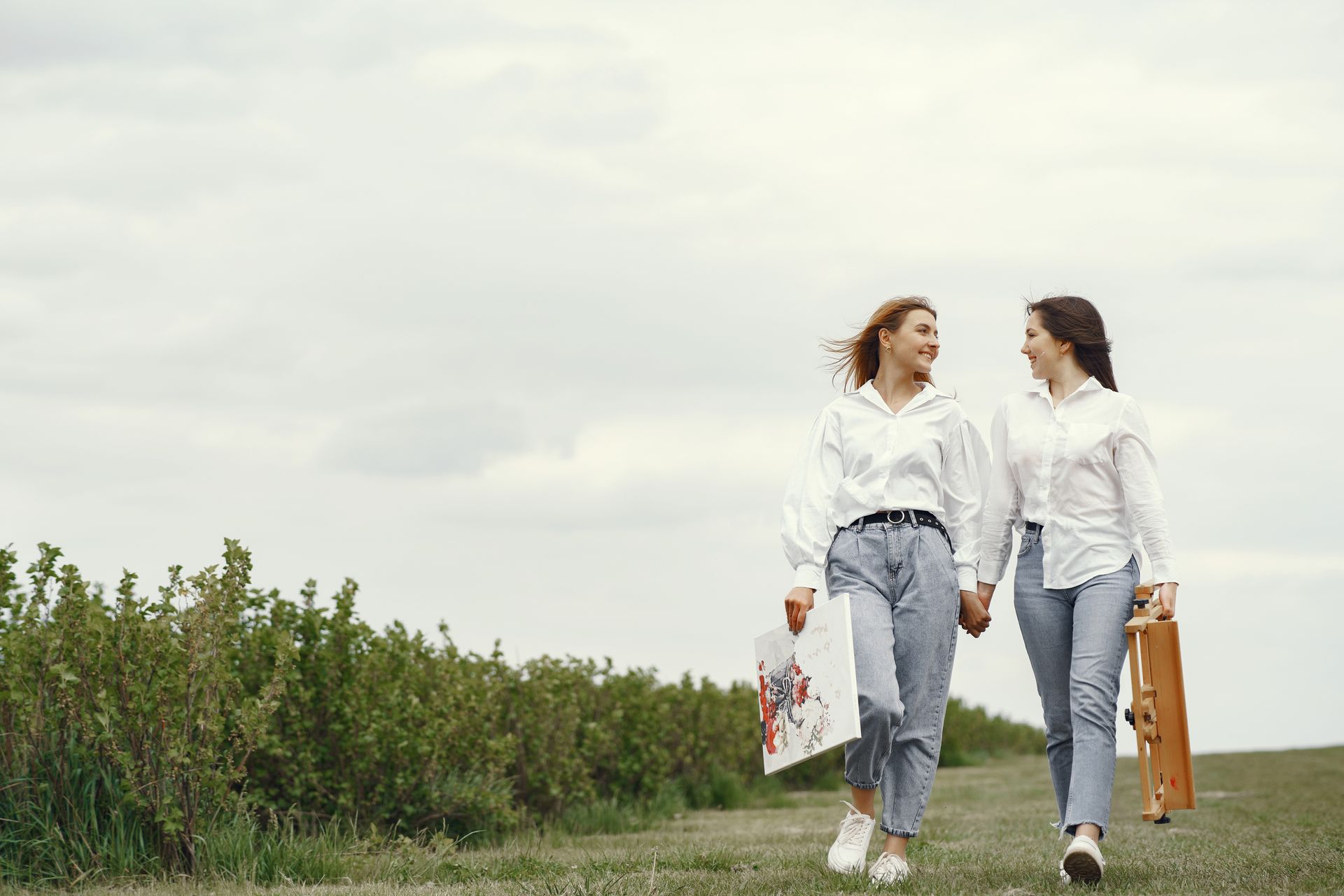A family is walking through a field holding hands.