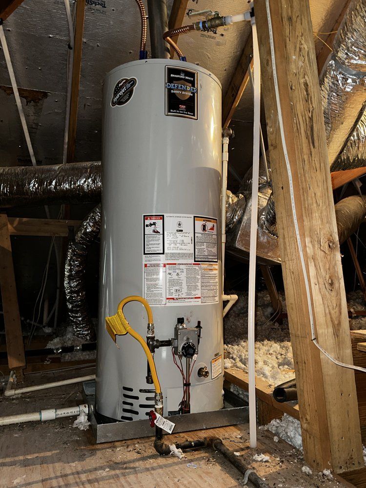 A water heater is sitting in the attic next to a wooden pole.