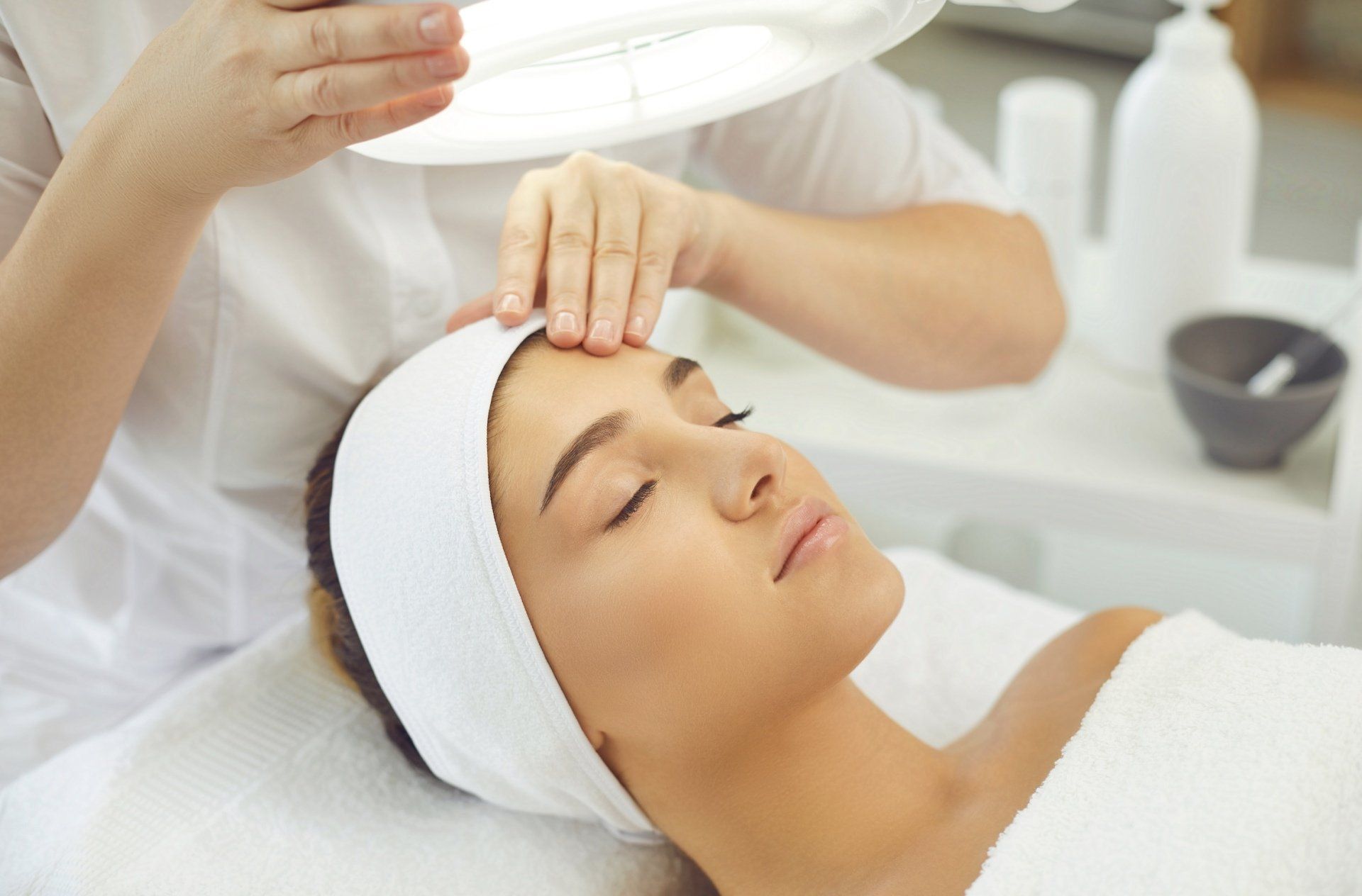 A woman is getting a facial treatment at a beauty salon.