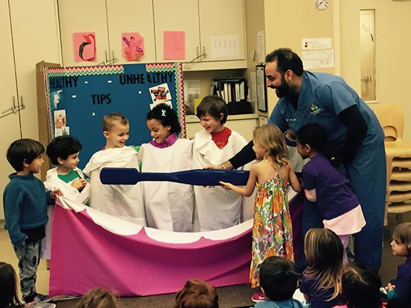 A group of children are standing in front of a bulletin board that says healthy tips