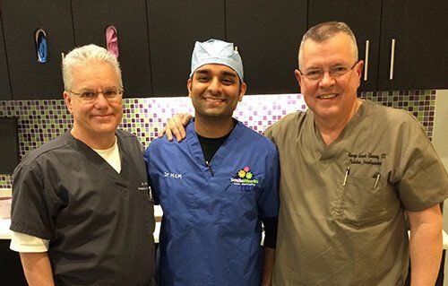 Three men in scrubs are posing for a picture together.
