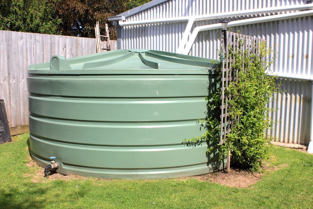 A Row Of Blue Tanks With A Yellow Railing On Top Of Them — Clear and Clean Water Tank Cleaning Services in Bridgman, NSW