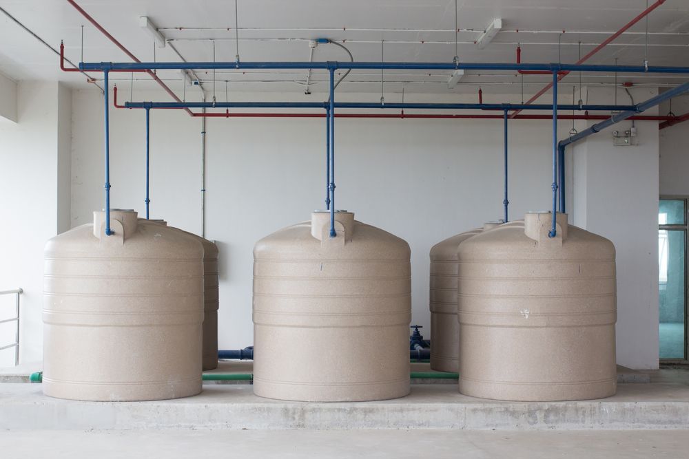 Three Water Tanks Are Lined Up Next To Each Other In A Room — Clear and Clean Water Tank Cleaning Services in Denman, NSW